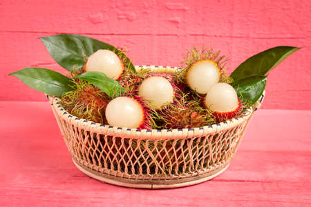rambutan fruit on wood color pink. in basket.の写真素材