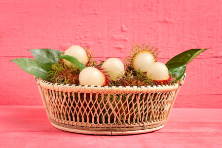 rambutan fruit on wood color pink. in basket.の写真素材