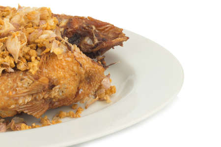 asia-asian food. thai food. fried nile tilapia river fish with garlic. on dish ceramic. isolated on...