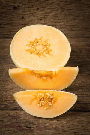 melon (sunlady) slice. half. on old wood. morning.の写真素材