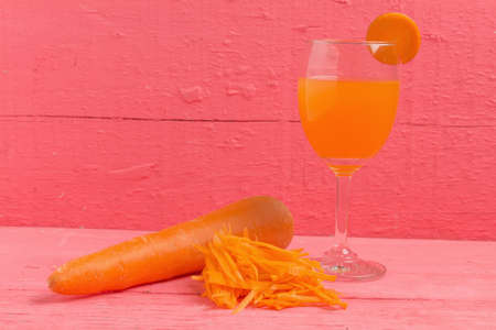 carrot sliced with glass juice carrot on wood pink.の写真素材