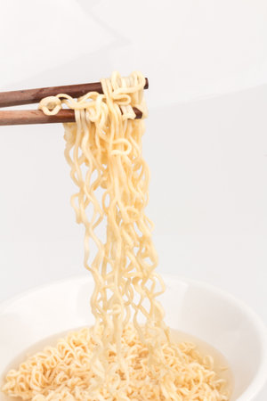 Noodles on a plate and chopsticks isolated on white background.