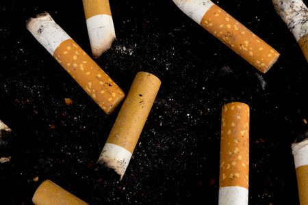 Cigarette butts isolated on black background.の写真素材