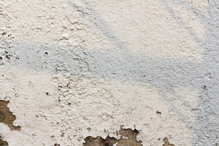 The white cement wall surface is peeling, dirty, old.の写真素材