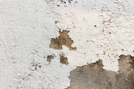The white cement wall surface is peeling, dirty, old.の写真素材