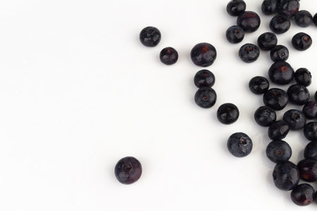 Blueberries scattered on a white background..