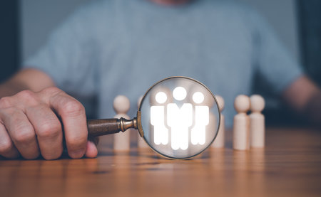 teamwork team leader HRM or Human Resource Management, businessman holding magnifying glass with icon in concept of human development team recruitment leadership and customer target group concept.の写真素材