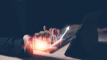 investment and finance concept, businessman holding virtual trading graph and blurred coins on hand, stock market, profits and business growth.	saving and investment plans retirement and fundの写真素材