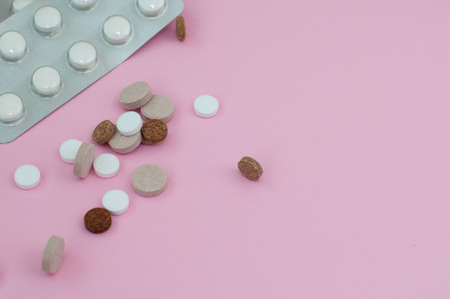 Assorted pharmaceutical medicine pills, tablets and capsules on pink background. Top view. Flat lay. Copy space. Medicine concept.の写真素材
