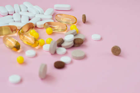 Assorted pharmaceutical medicine pills, tablets and capsules on pink background. Top view. Flat lay. Copy space. Medicine concept.の写真素材