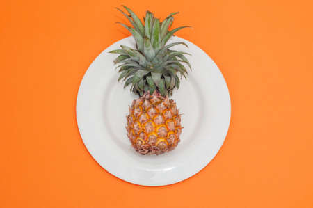 Yellow pineapple on a white plate, flat lay, horizontal orientation,の写真素材
