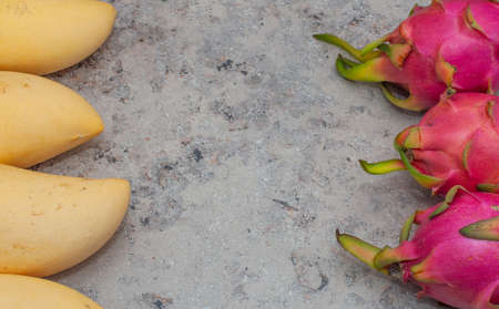 yellow mango and pitahaya on a gray background. Horizontal Orientation. Place for text. Copy spaceの写真素材