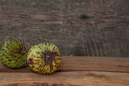 Cherimoya fruit on wooden table background. Two cherimoyas. Close up,Annona cherimolaの写真素材