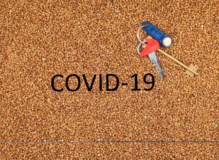 Buckwheat deficiency concept. Coronavirus pandemic concept. Buckwheat groats closeup. Buckwheat texture with the inscription coronovirus and key.の写真素材