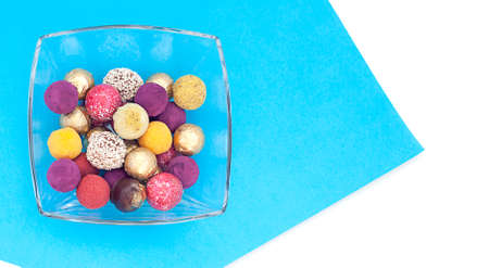 handmade chocolate truffles, different colors on a platter on a blue and white background.の写真素材