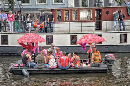 Amsterdam, Holland - August 04, 2012: People celebrate the gay parade, celebration on the canals of Amsterdam. People with lgbt flags.のeditorial素材