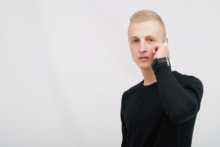 Young man talking on his mobile phone isolated on white backgroundの写真素材