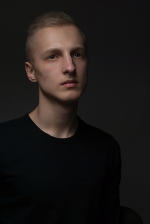 Young blonde man portrait in studio on gray backgroundの写真素材