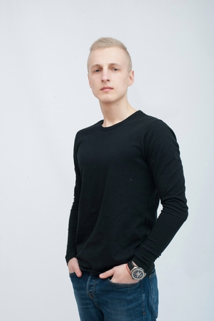 Young blonde man portrait in studio on gray backgroundの写真素材