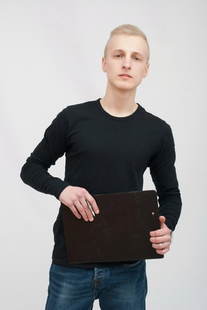 Businessman with tablet. Young blonde man portrait in studio on gray backgroundの写真素材