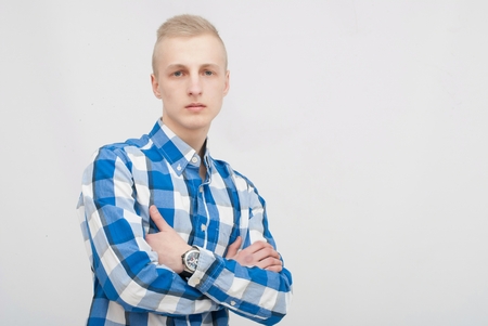 Young blonde man portrait in studio on gray backgroundの写真素材
