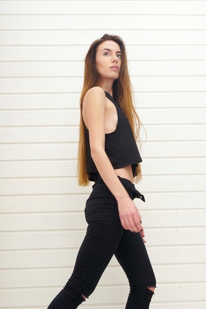 girl in black clothes on a light background of the trends this season beautiful hair and makeup face incredibly beautifulの写真素材