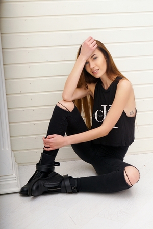 girl in black clothes on a light background of the trends this season beautiful hair and makeup face incredibly beautifulの写真素材