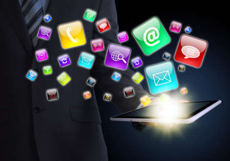 Man in suit holding tablet in hand  Application icons around tablet  The concept of software