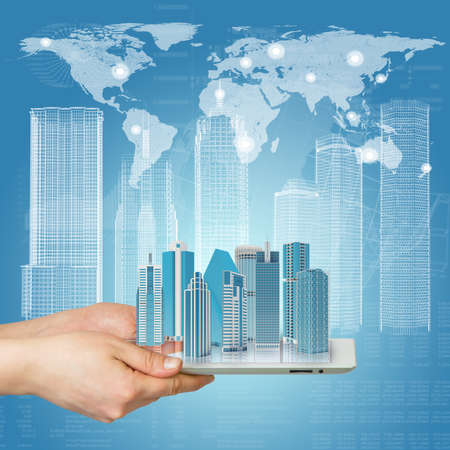 Hands holding a tablet computer  In screen tablet city of skyscrapers