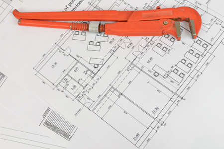 Adjustable wrench and drawing on the desktop  Concept of repair and construction