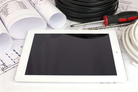Electrical cable and tablet pc on the construction drawings  Repair and construction of electric...