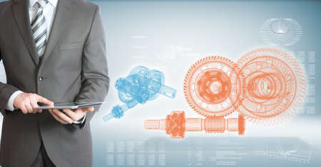 Businessman hold tablet pc  High-tech wire frame gears and graphs at backdrop
