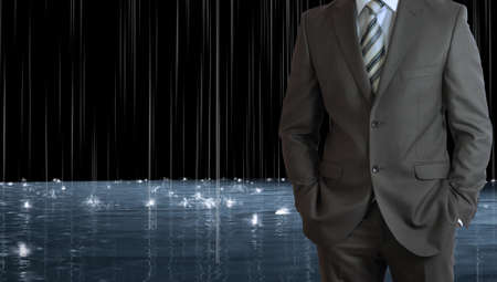 Businessman standing with hands in pockets  Rain and surface waters as backdropの写真素材
