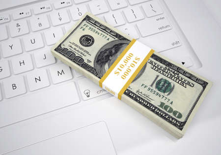 Bundle of dollar bills lying on a computer keyboard  View from aboveの写真素材