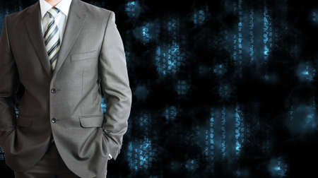 Businessman in a suit with background of blue glowing figuresの写真素材
