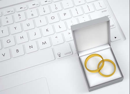 Box for jewelry with two gold rings on the keyboard.  View from aboveの写真素材