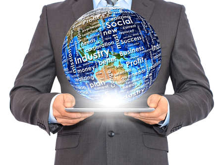 Businessman holds tablet pc with Earth in hand  On the globe written business words の写真素材
