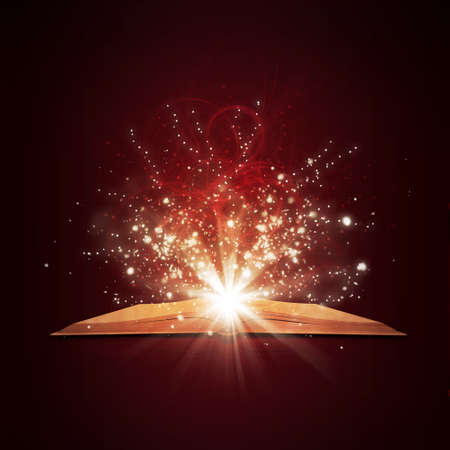 Old open book with magic light and falling stars  Dark backgroundの写真素材