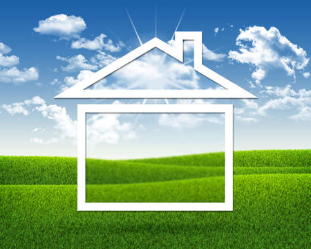 House icon on background of green grass and blue skyの写真素材