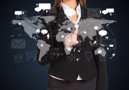 Businesswoman in a suit presses the virtual world mapの写真素材
