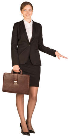 Businesswoman holding a briefcase and shows his hand towardsの写真素材