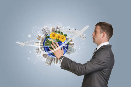 Businessman hold Earth with buildingsの写真素材