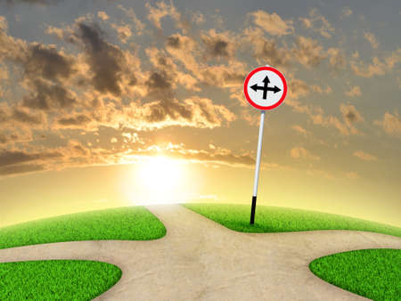 Crossroads road sign. Green grass, fork in the way and sky as backdropの写真素材