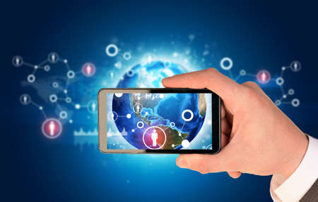 Man hand holding smart phone. Image of Earth on phone screen.