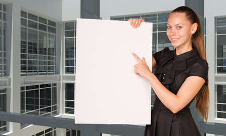 Businesswoman holding empty paper. Large window in office building の写真素材