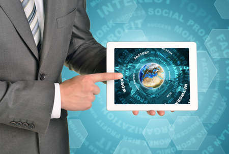 Man hands using tablet pc. Earth and business words on touch screen.  