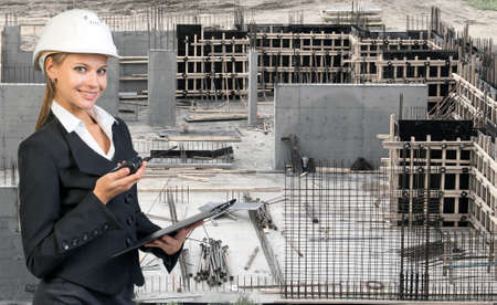Beautiful businesswoman in suit and helmet holding paper holder and portable radio. Construction...