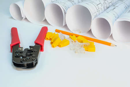 Drawing rolls, crimping pliers, connectors, boot caps, pencil on white surfaceの写真素材