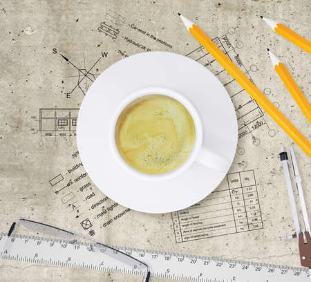 Technical plan of building, pencils, ruler, compasses, eyeglasses and cup of coffee Top view, on smooth stone surfaceの写真素材