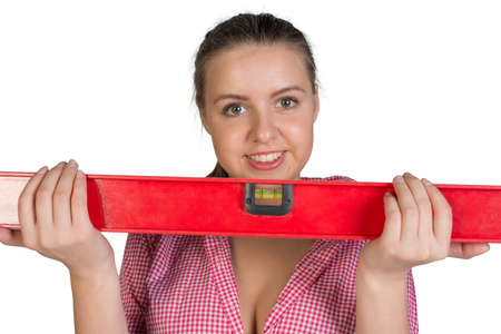Woman holding builders level, looking at camera, smiling. Isolated on white background